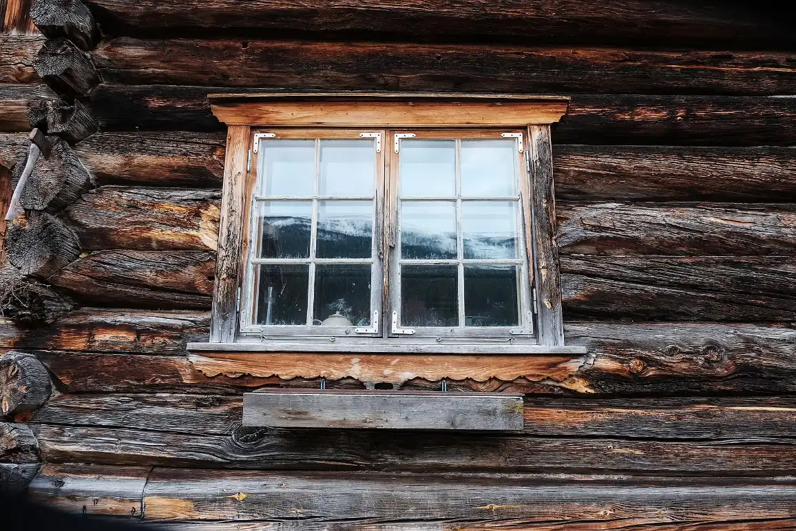 Sprossenfenster in einer Wand aus alten Holzbohlen
