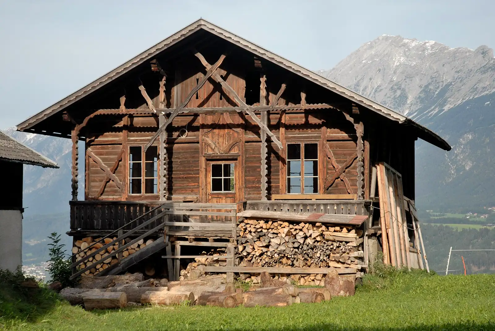Holzhaus mit Veranda, Holzfenstern und Fensterläden